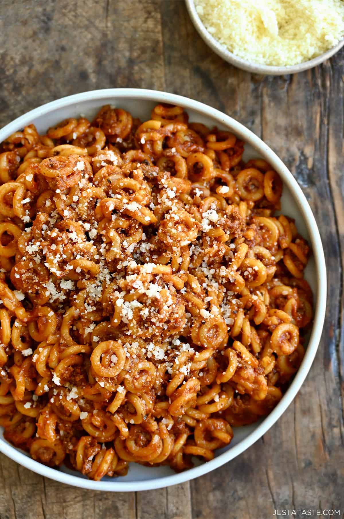 Homemade SpaghettiOs topped with grated parmesan cheese in a dinner bowl.