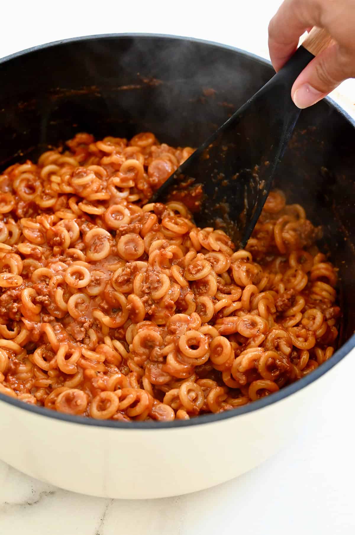 Homemade Spaghetti Os in a white Dutch oven.