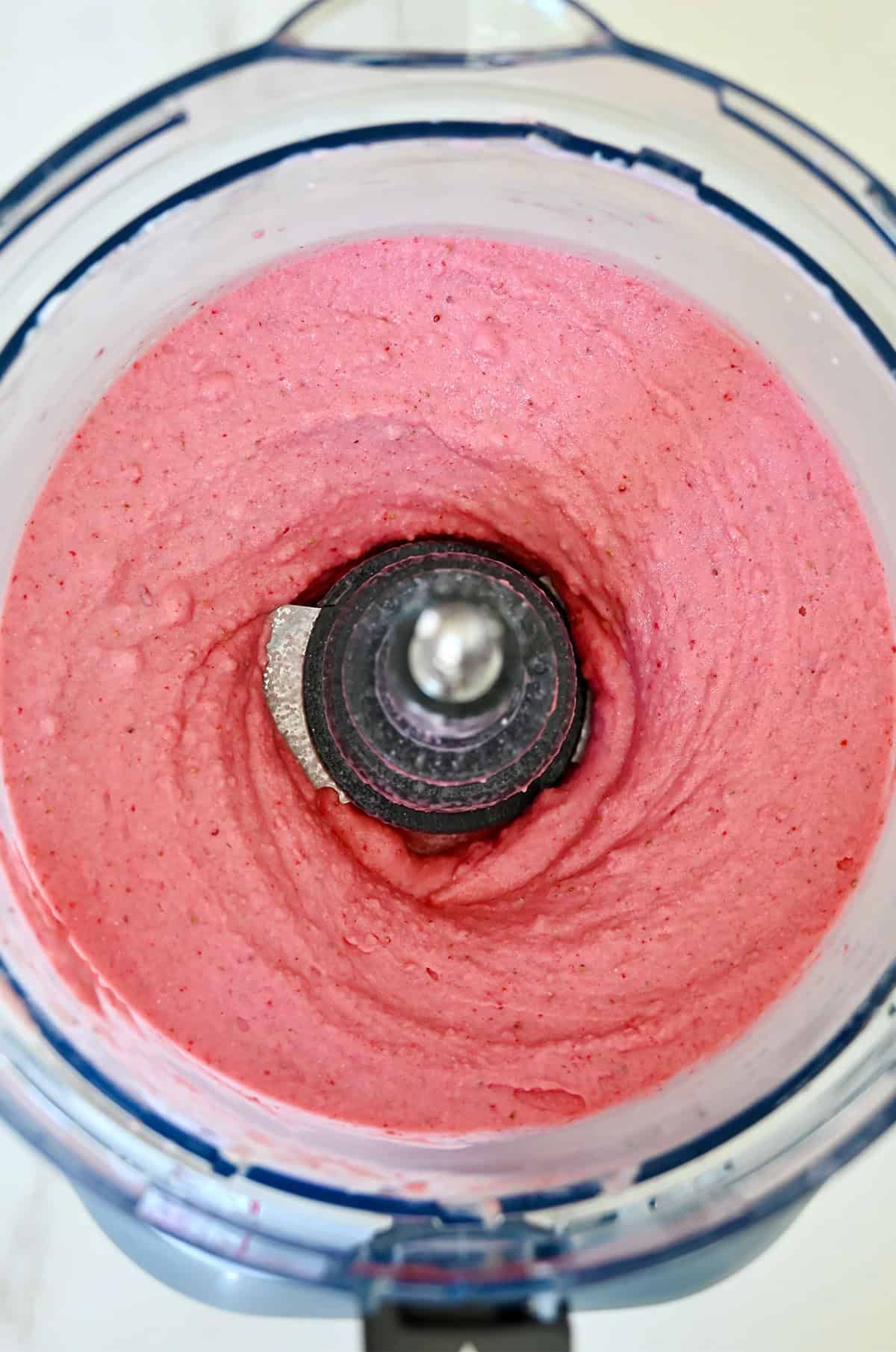 Creamy strawberry cottage cheese ice cream in a food processor.