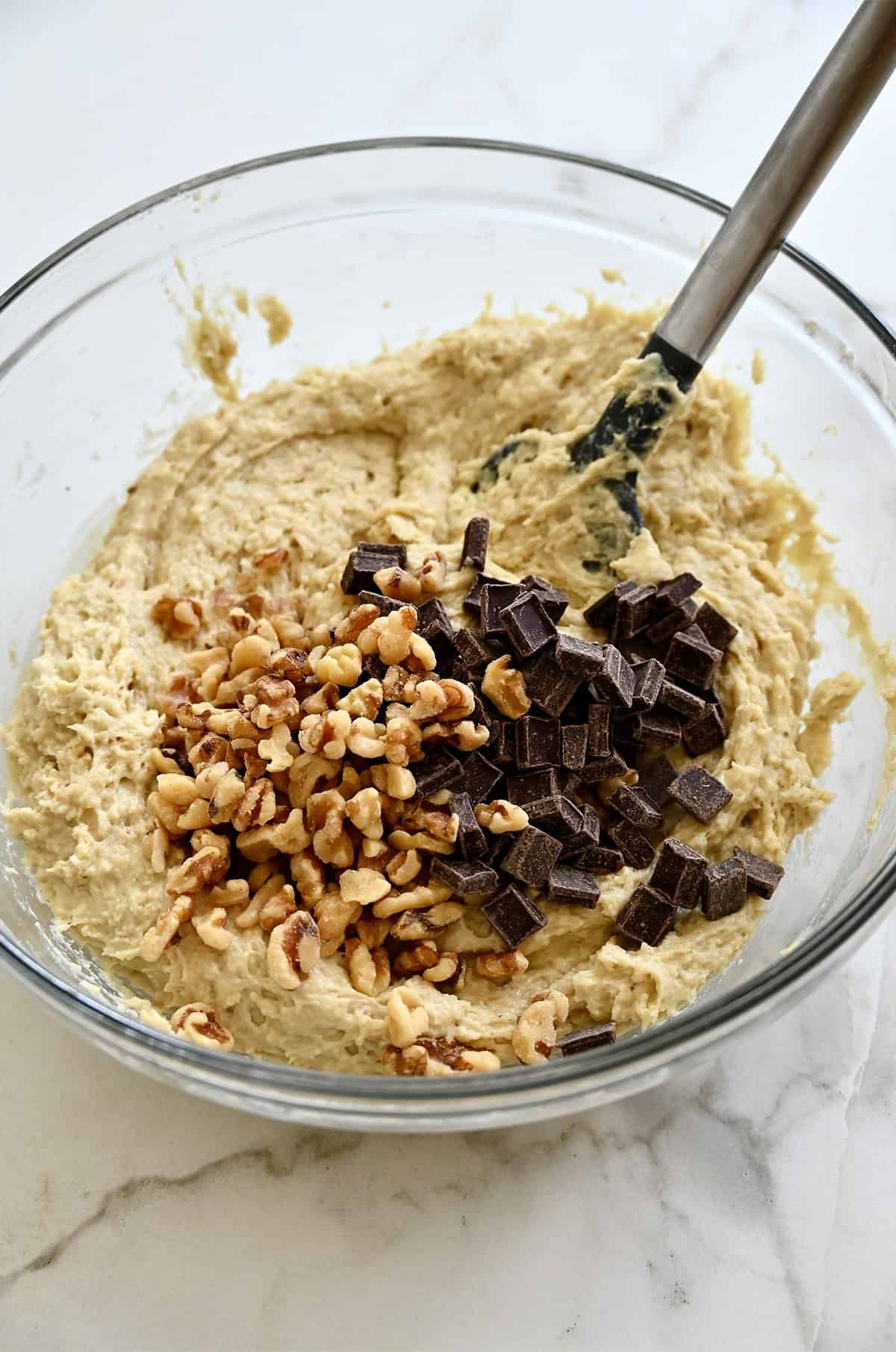 Folding chocolate chunks and chopped walnuts into cottage cheese banana bread batter.
