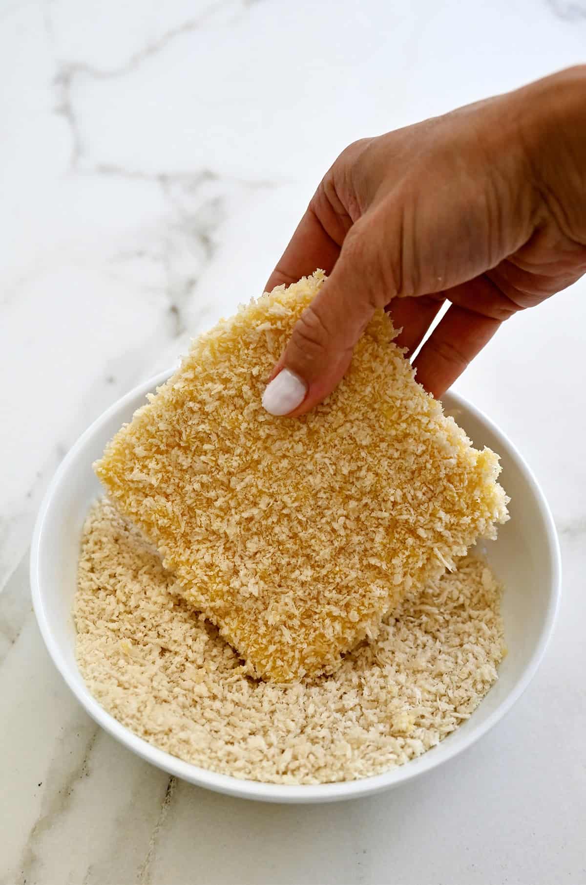 Double-dredged mozzarella being dredged in Panko for a second time.
