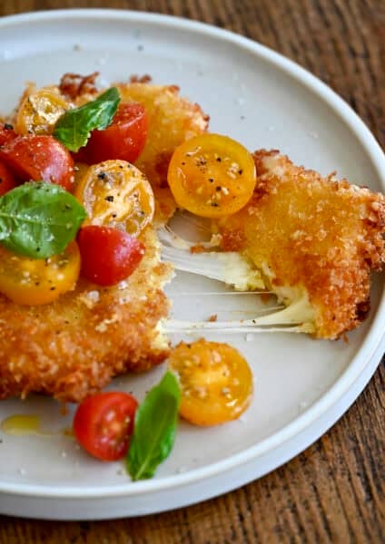 Gooey fried mozzarella topped with a cherry tomato and basil salad.