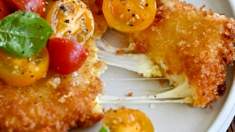 Gooey fried mozzarella topped with a cherry tomato and basil salad.