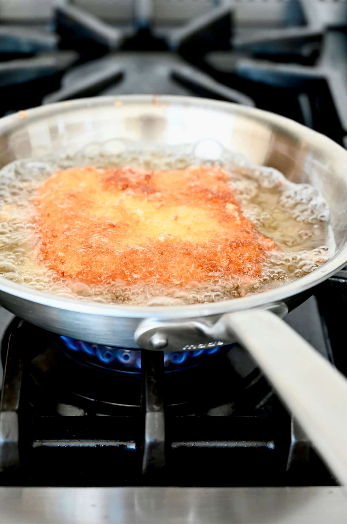 Frying breaded mozzarella in a pan.