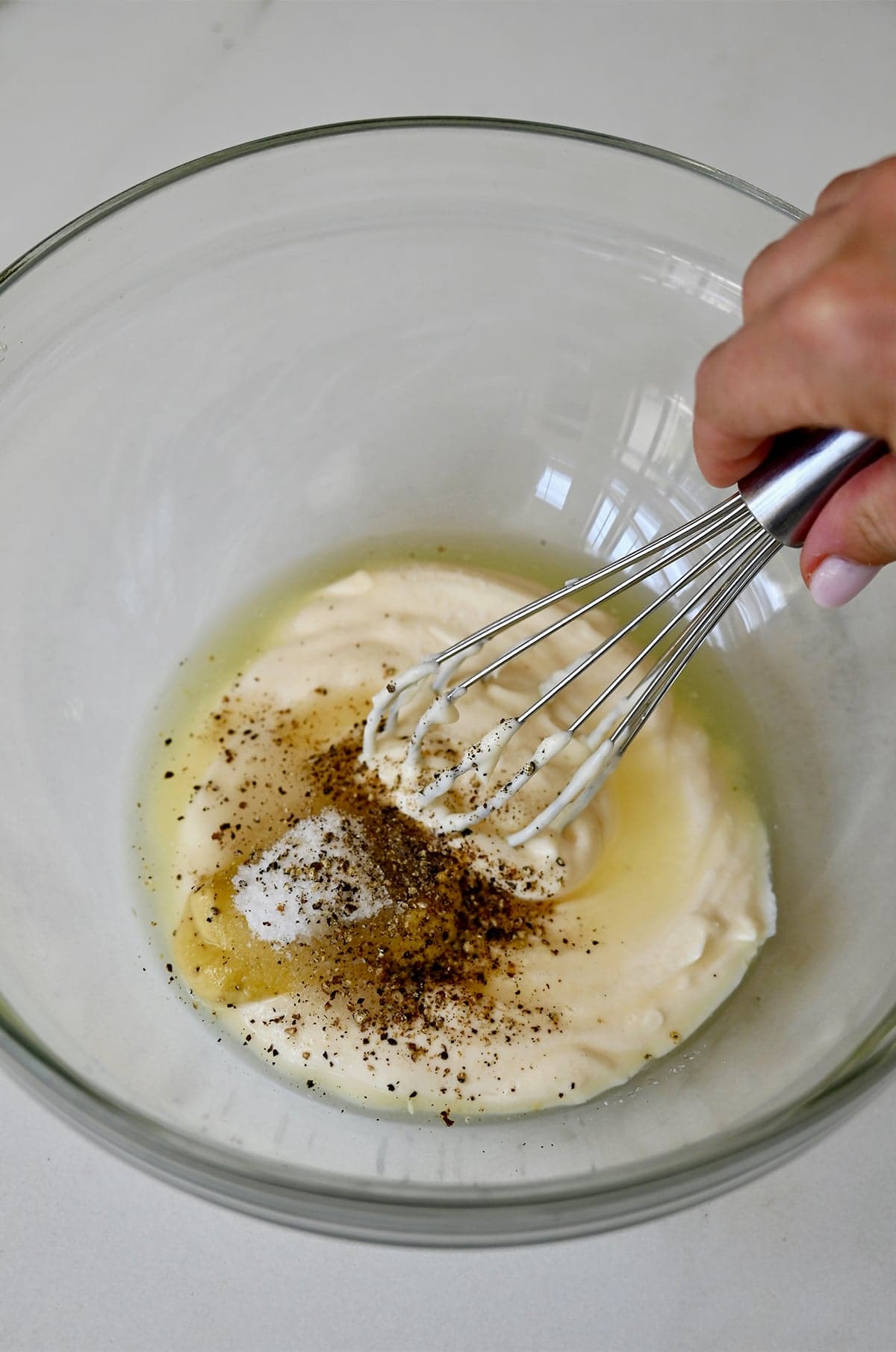 Mayo, Dijon and lemon dressing for chicken salad being whisked in a large bowl.
