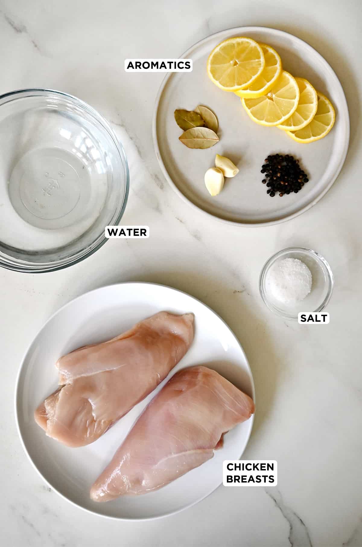 Ingredients to make poached chicken, including boneless chicken breasts, water, salt and aromatics.