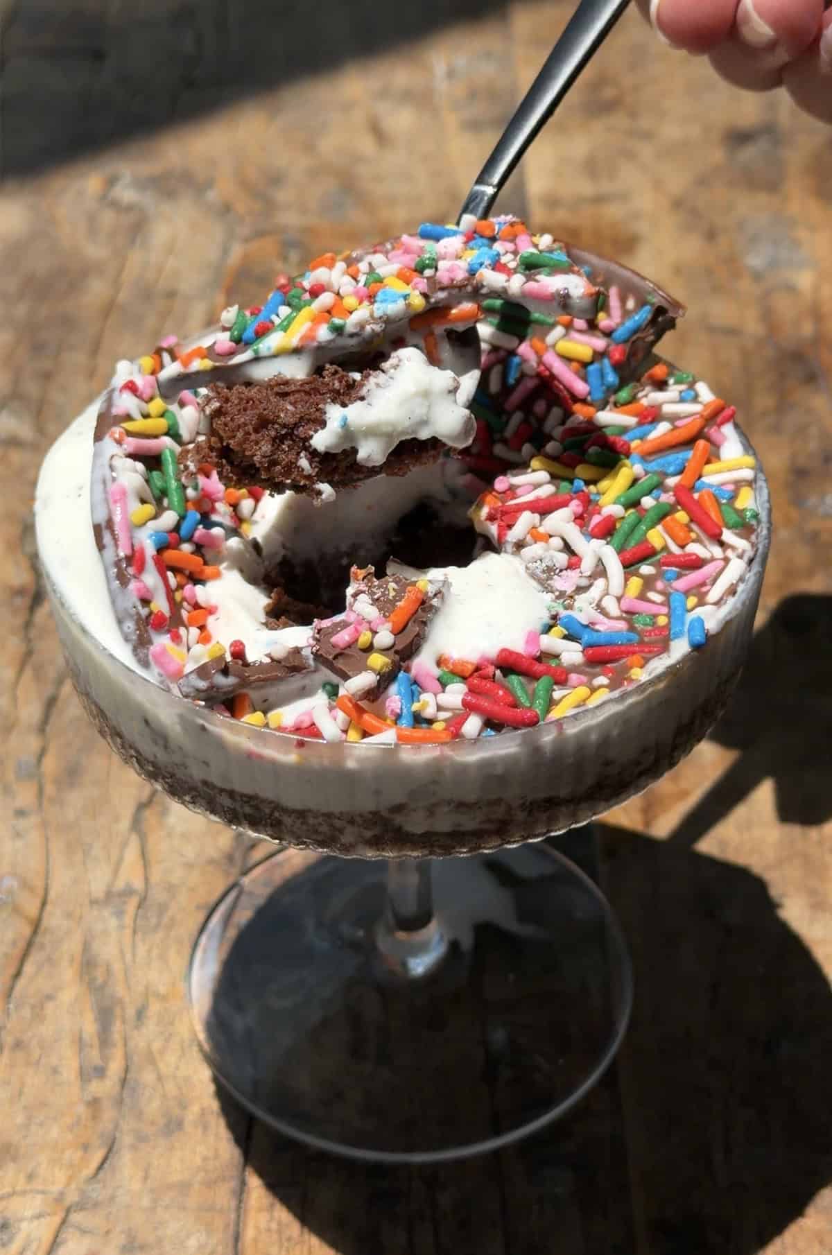 Taking a scoop out of an ice cream cocktail cake.