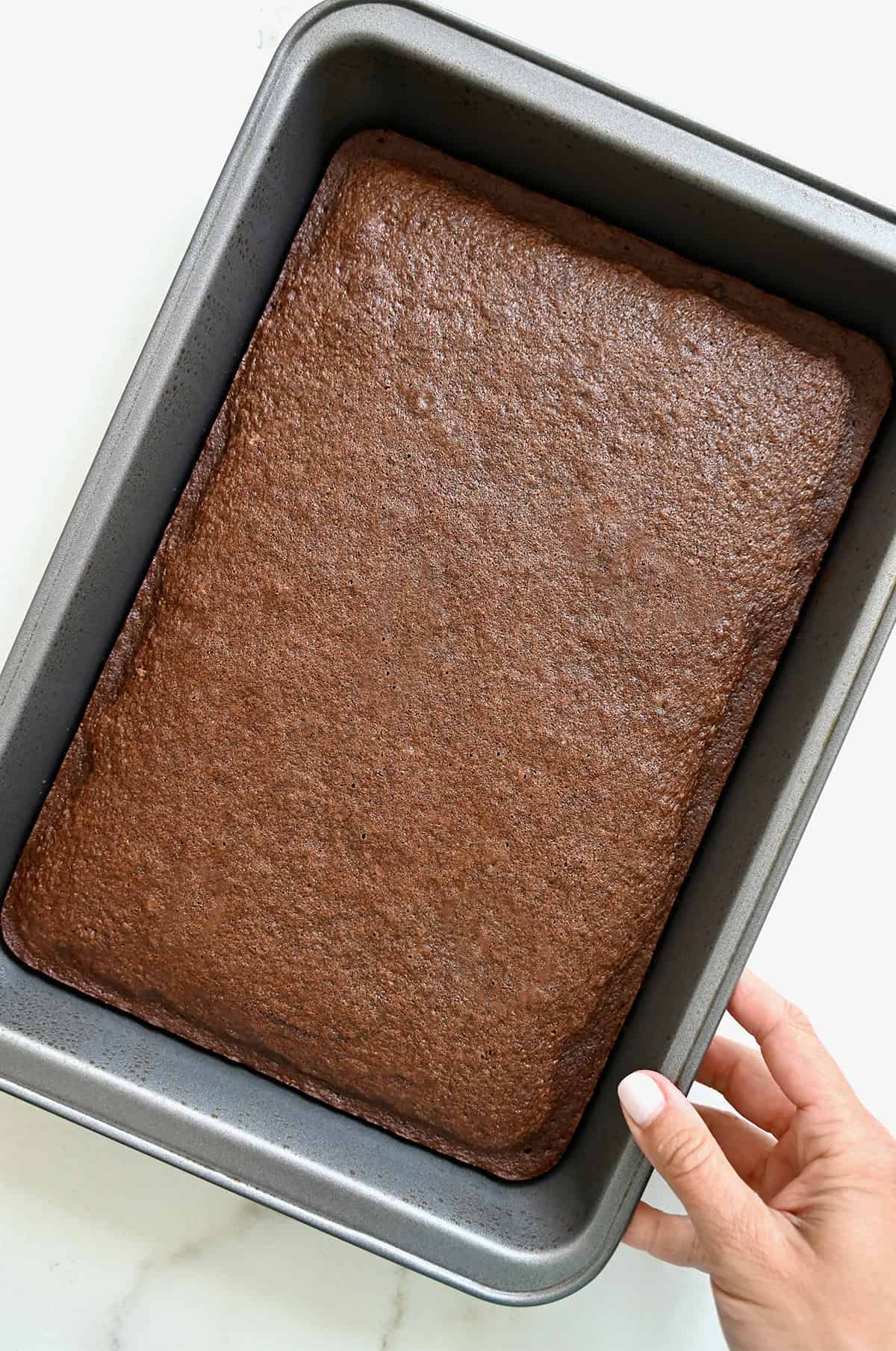 Moist chocolate cake in a 9x13 metal pan.