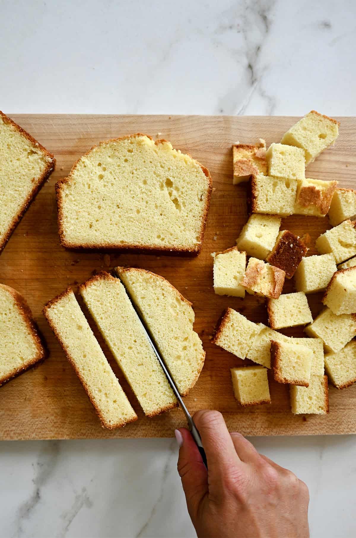 Cutting homemade pound cake into 1-inch cubes.