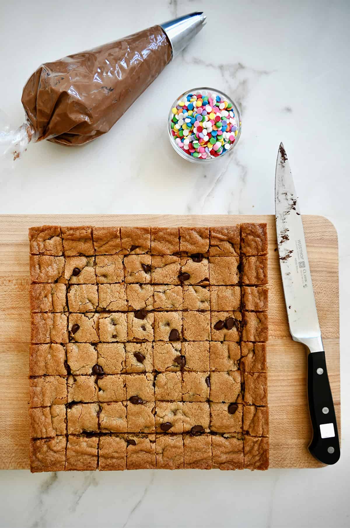 Cutting a square cookie cake into cubes.