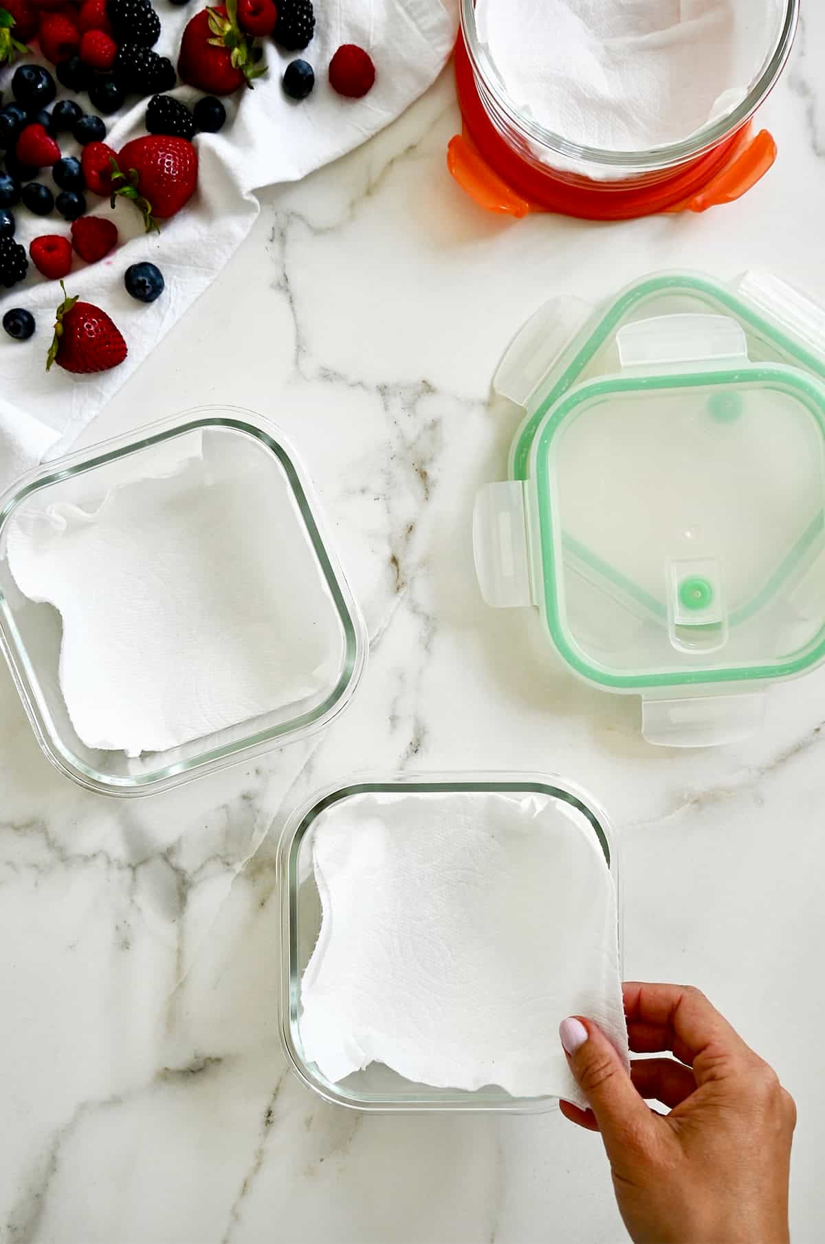 Lining glass containers with paper towels to store fresh berries.