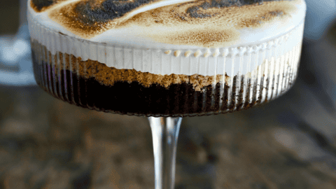 S'mores cake in a cocktail glass with toasted marshmallow fluff.