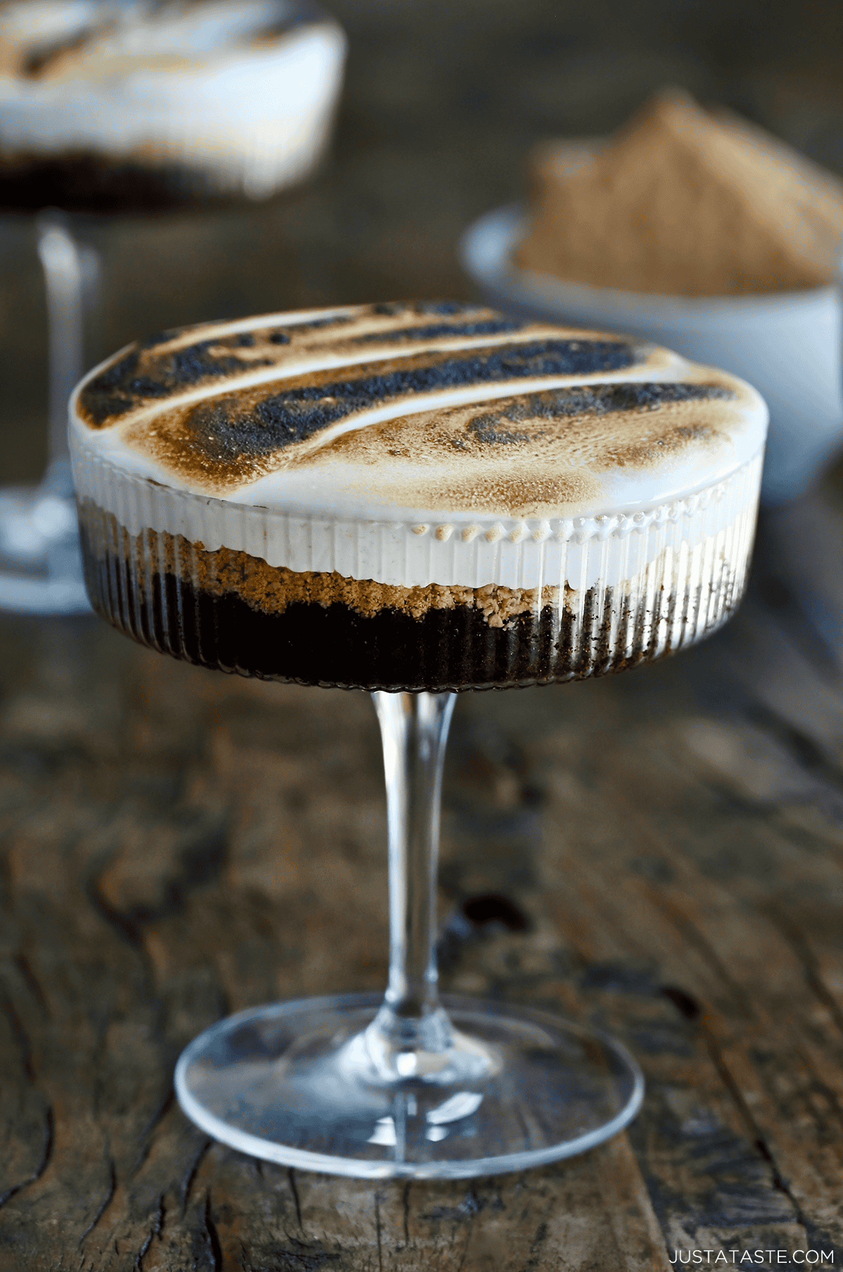 S'mores cake in a cocktail glass with toasted marshmallow fluff.