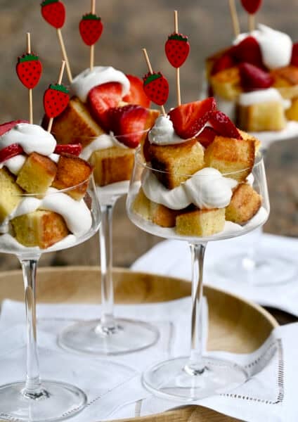 Cocktail glasses filled with toasted buttery pound cake layered with whipped cream and fresh strawberries.