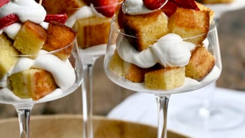 Cocktail glasses filled with toasted buttery pound cake layered with whipped cream and fresh strawberries.