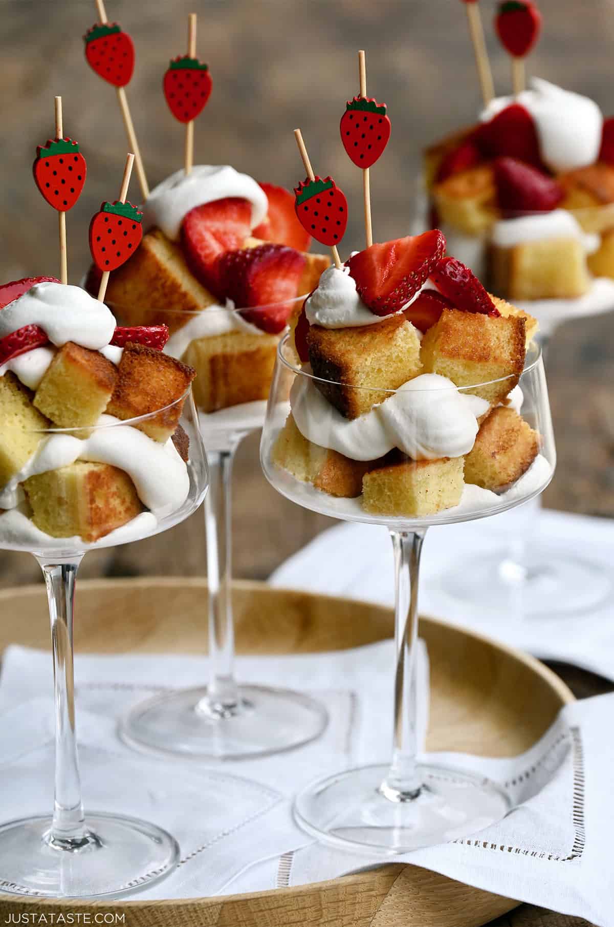 Cocktail glasses filled with toasted buttery pound cake layered with whipped cream and fresh strawberries.