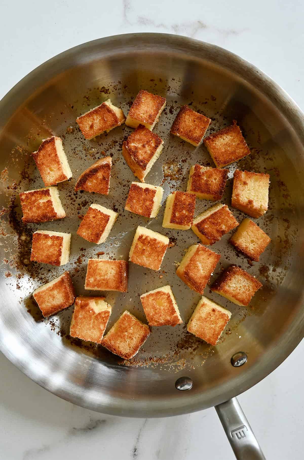 Toasted pound cake in a skillet.