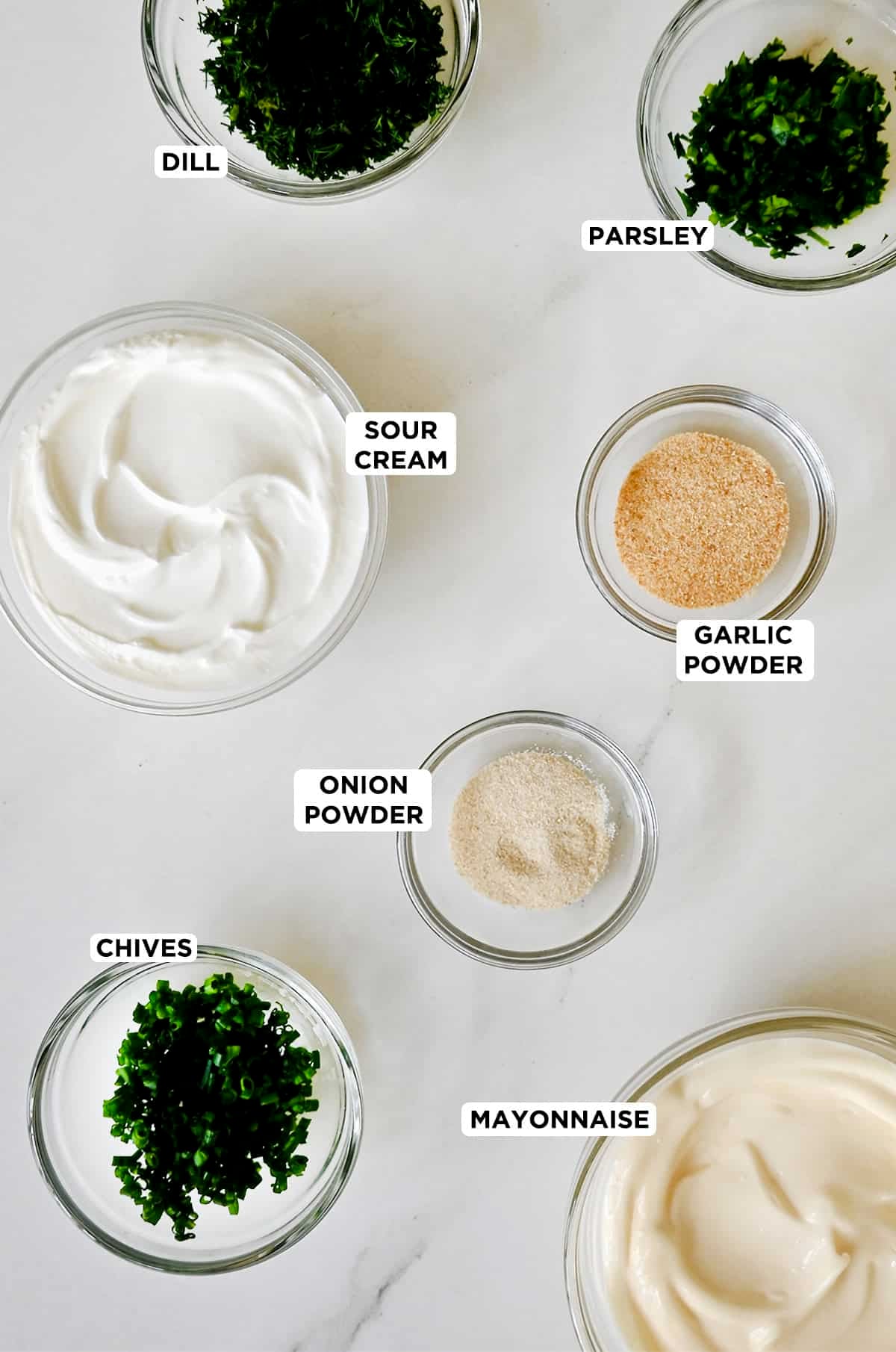 Veggie dip ingredients in various sizes of glass prep bowls.