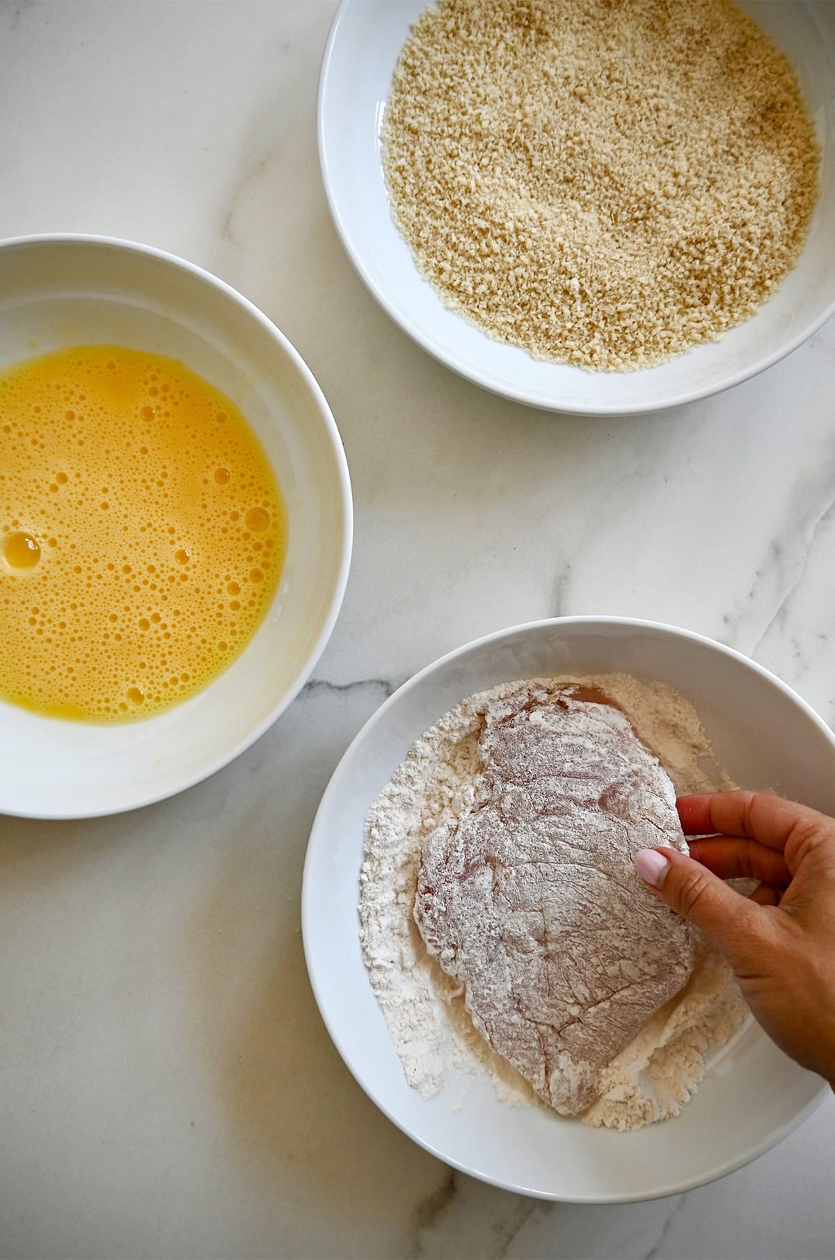 Breading thin chicken cutlets in flour, eggs and Panko breadcrumbs.