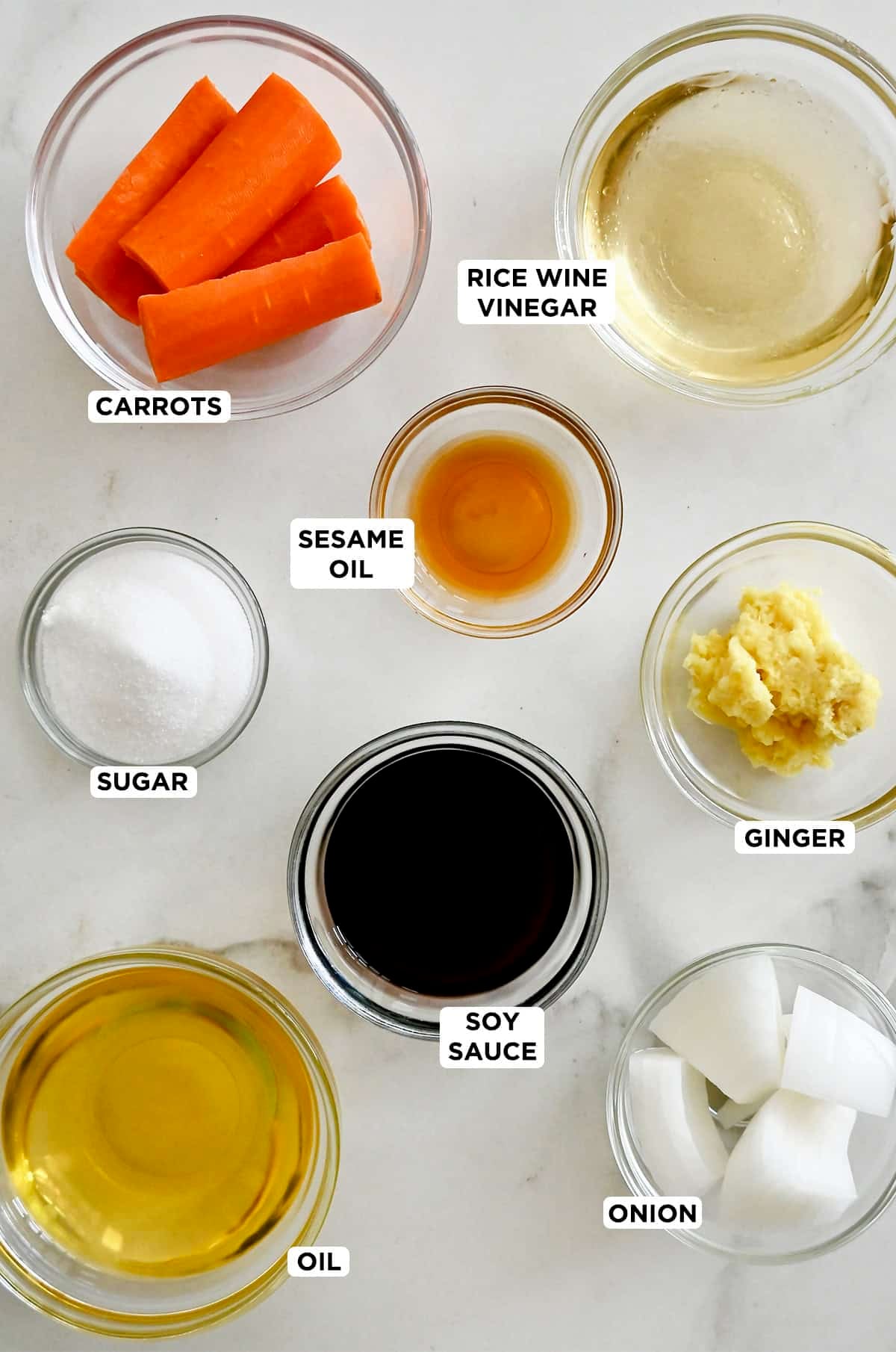Carrot-ginger dressing ingredients in various sizes of glass prep bowls.