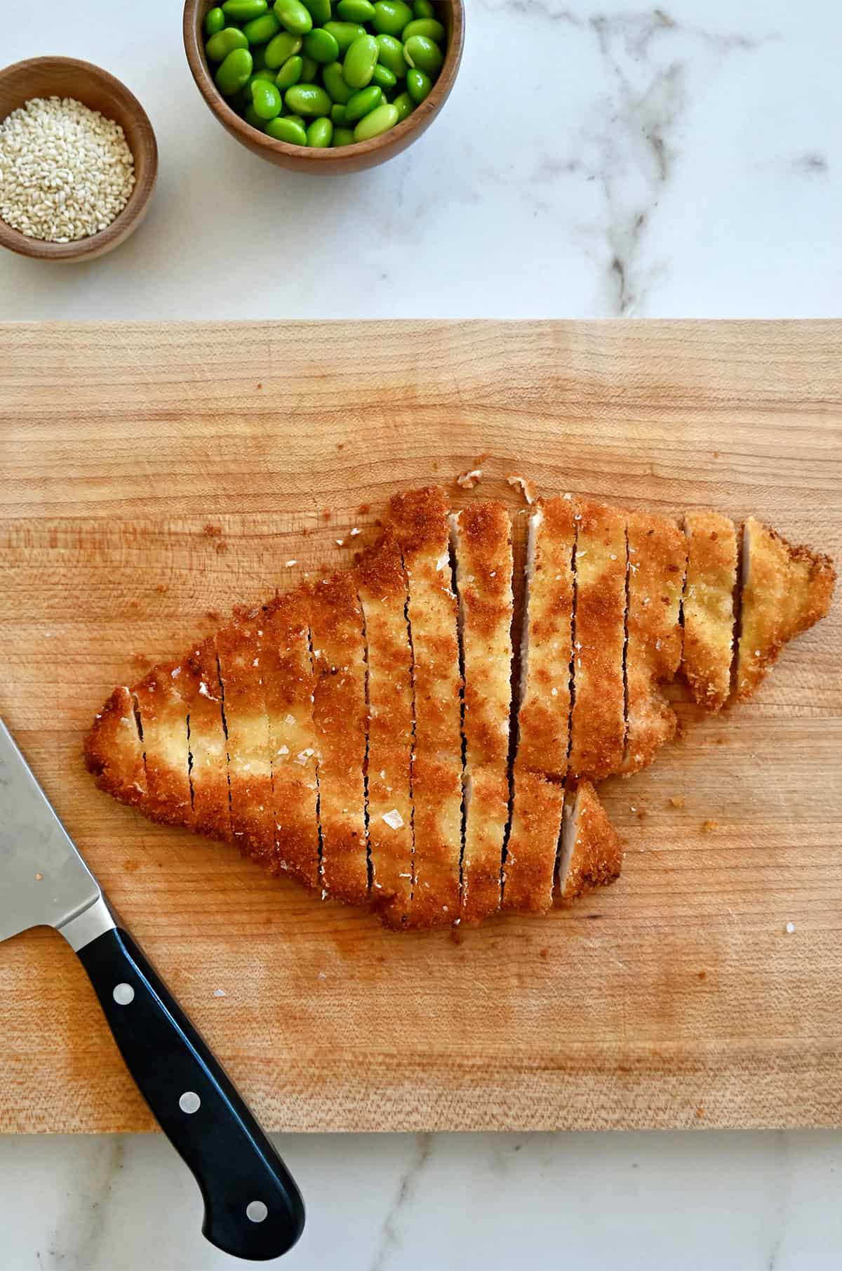 Crispy chicken katsu on a cutting board.