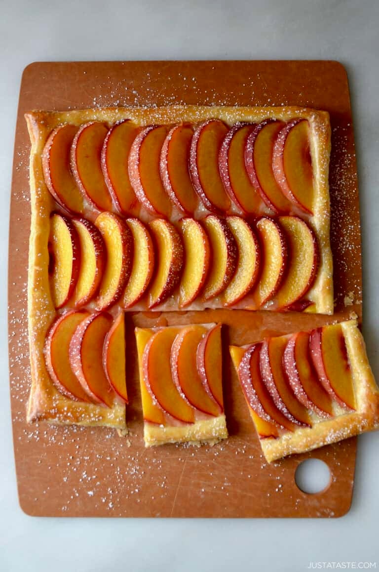 Fresh peach tart made with store-bought puff pastry and dusted with powdered sugar.