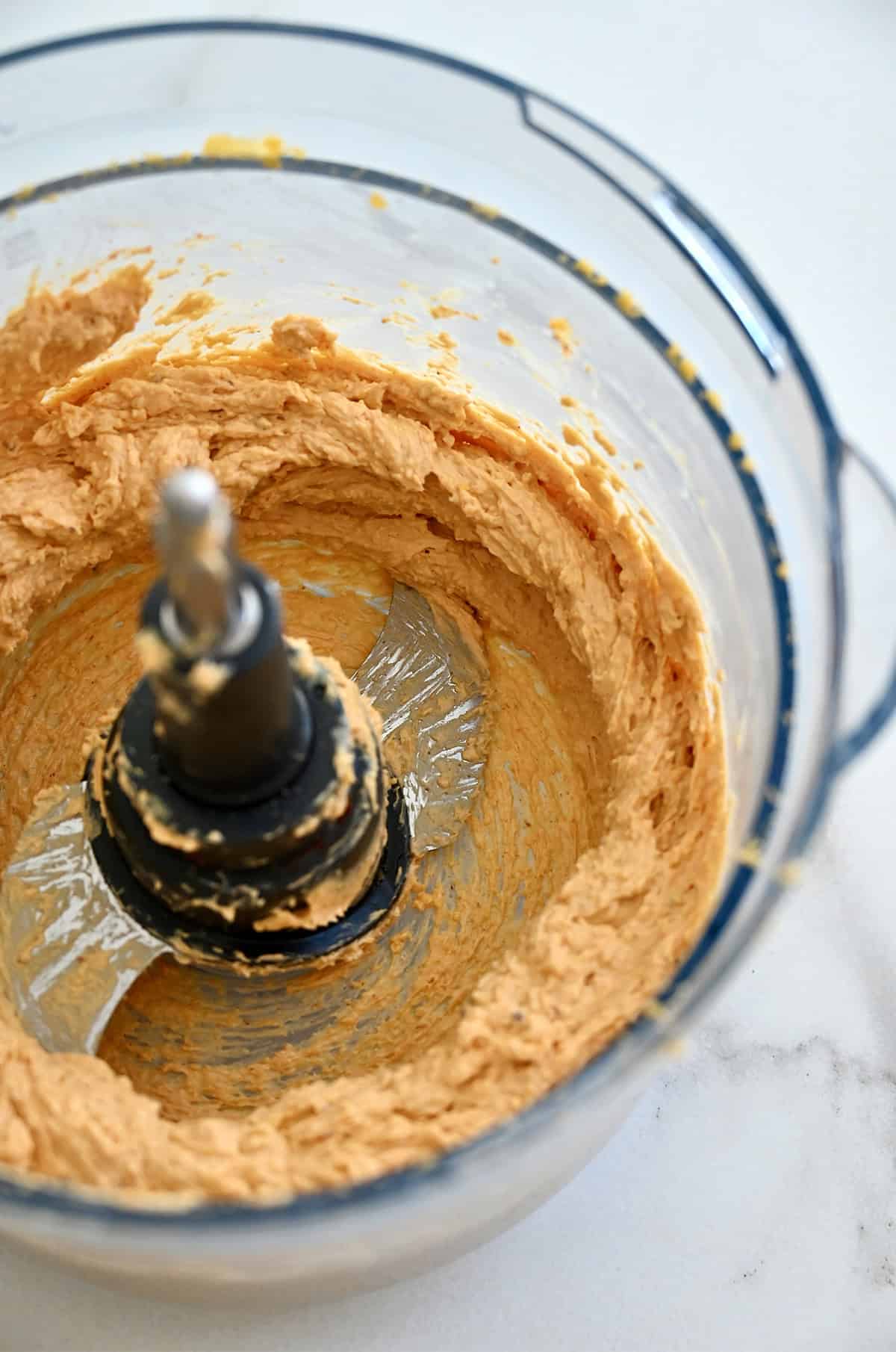Homemade pub cheese in the bowl of a food processor.