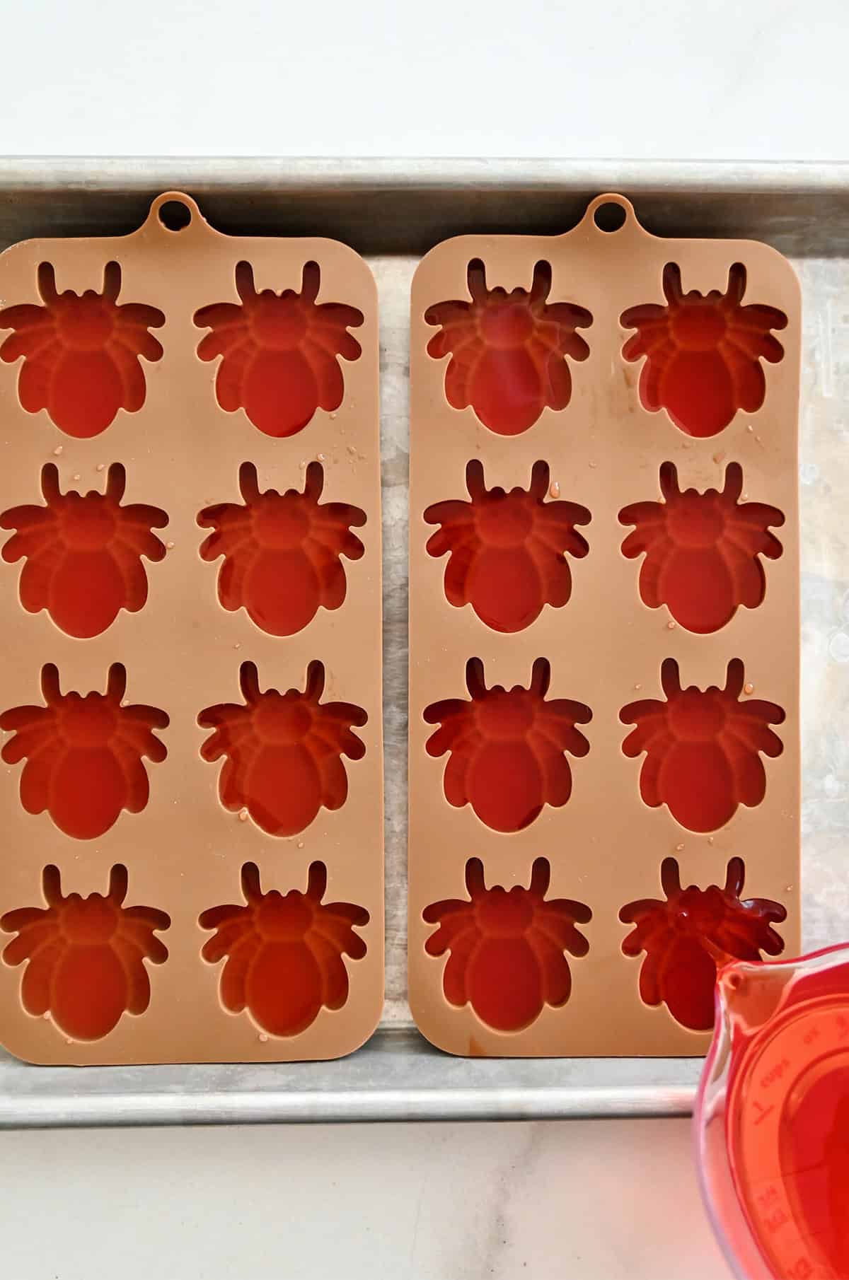 Making frozen lemonade and grenadine spiders using silicone molds.