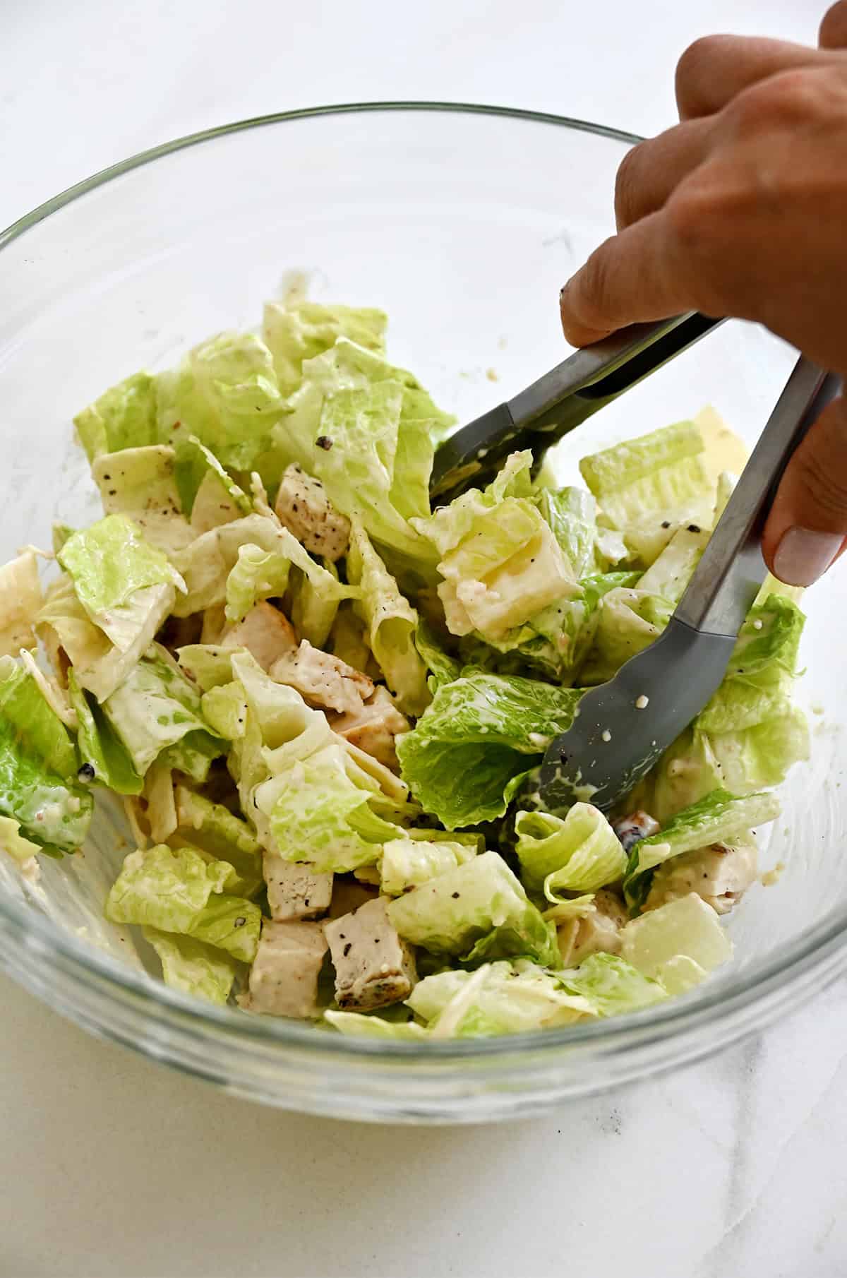 Tossing all the ingredients together to make a Caesar salad filling for a wrap.