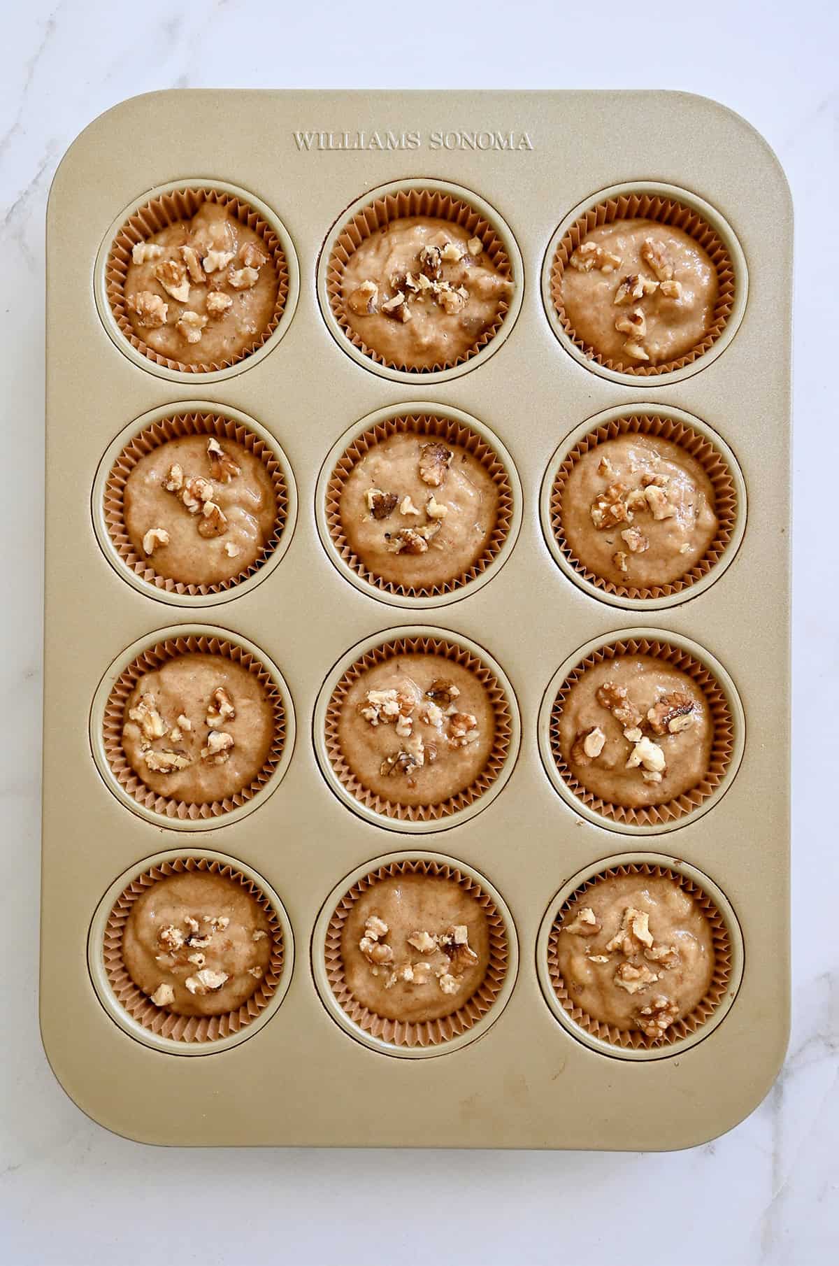 Muffin liners filled ¾ full with muffin batter.