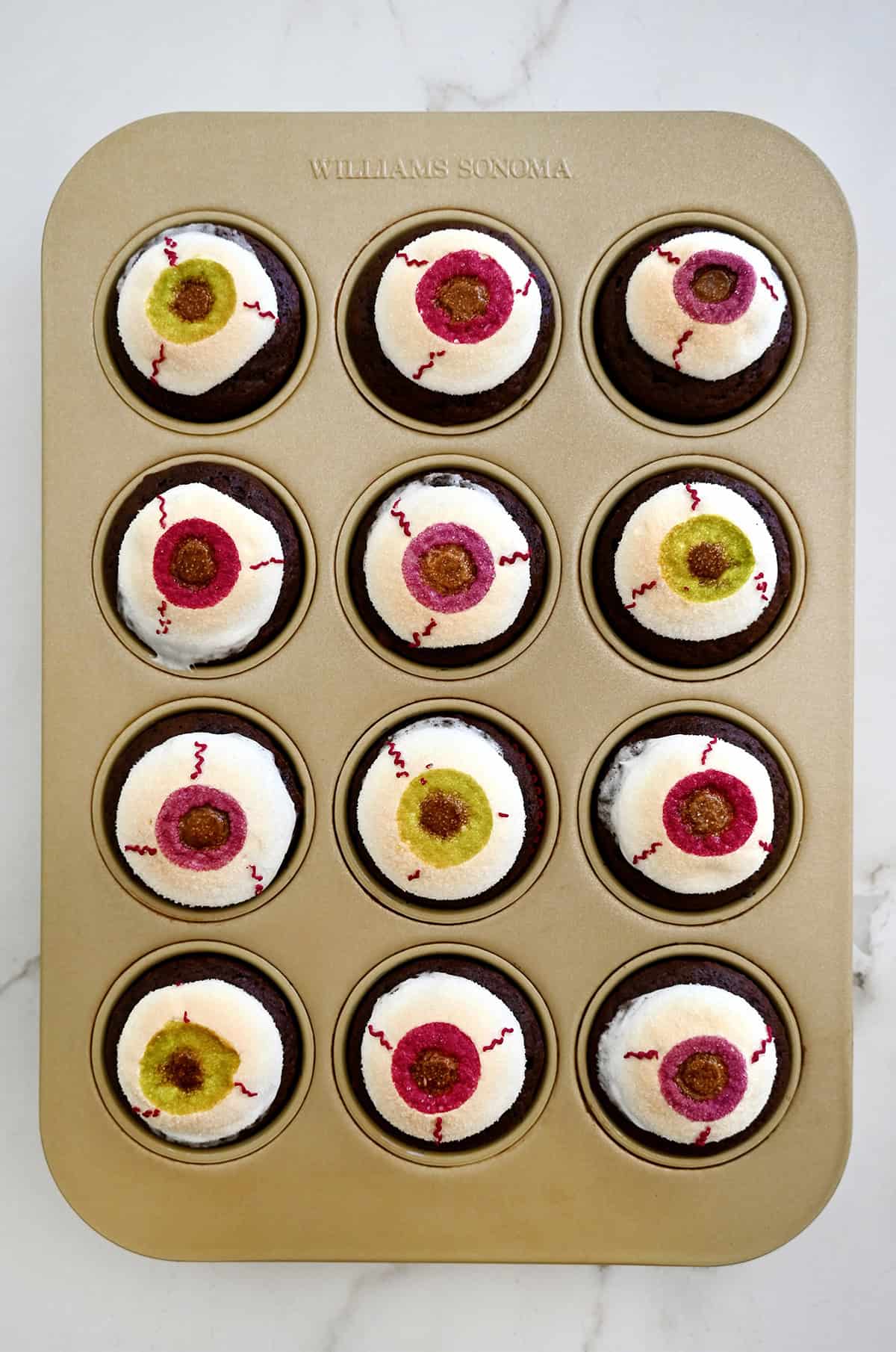 Chocolate Halloween cupcakes topped with puffed and toasted marshmallow eyeballs.
