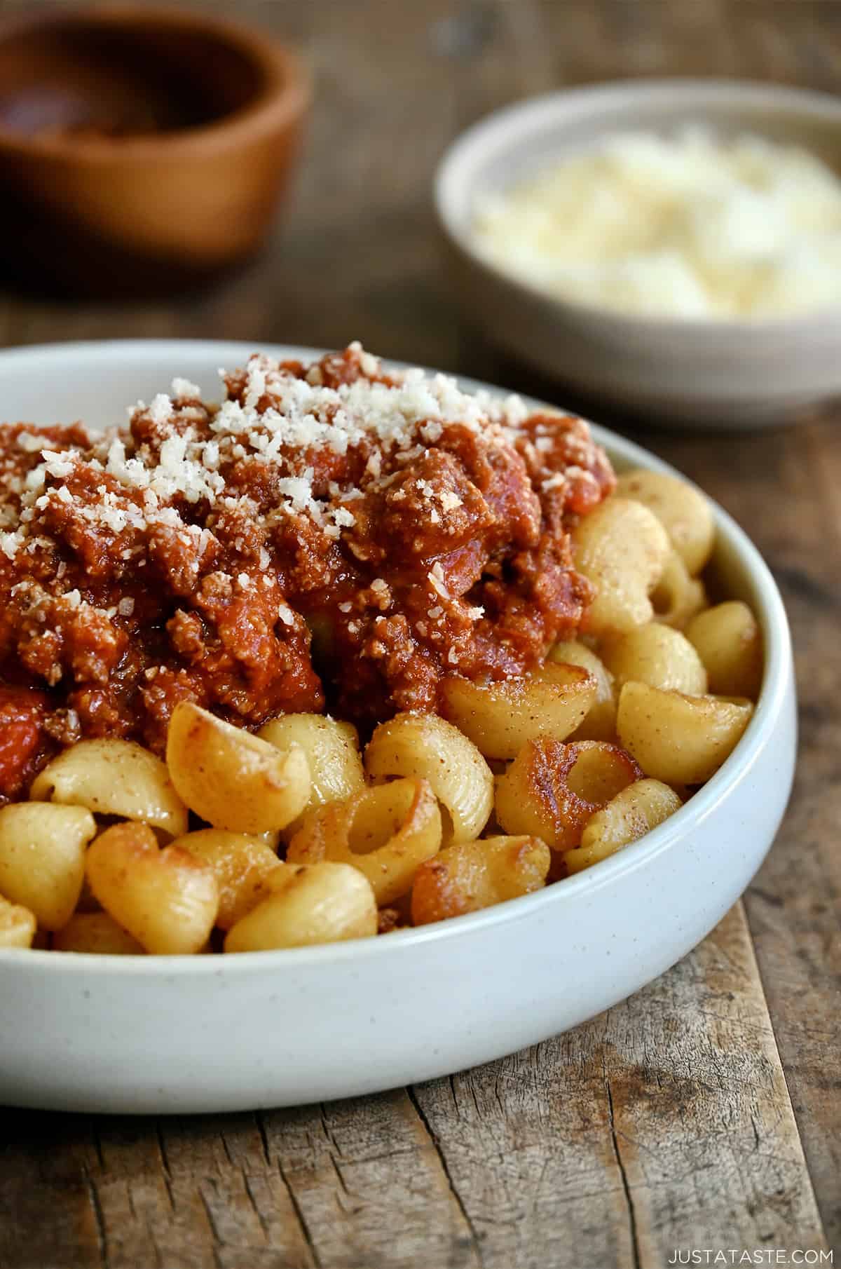 Fried spaghetti with Bolognese sauce in a shallow pasta bowl.