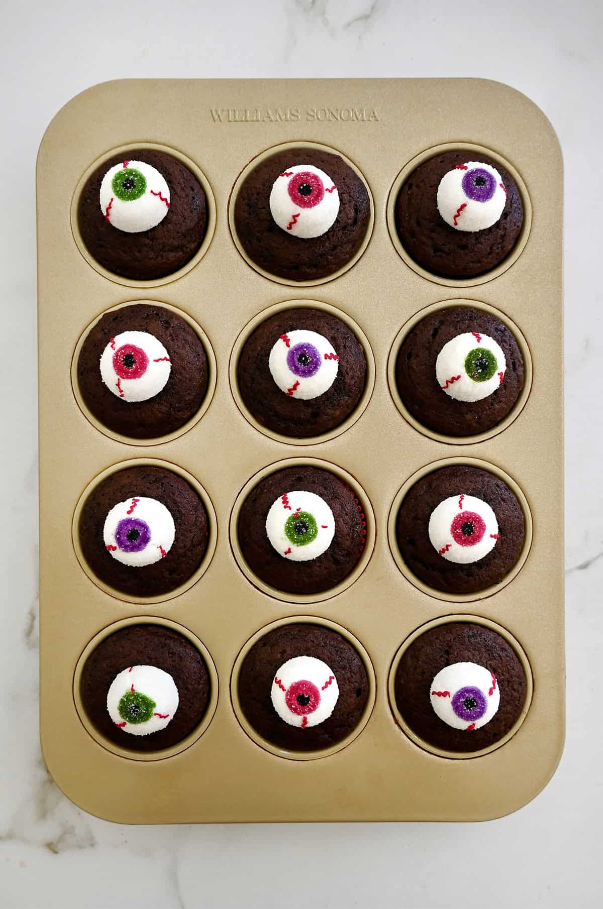 Chocolate cupcakes topped with unbaked marshmallow eyeballs for Halloween.