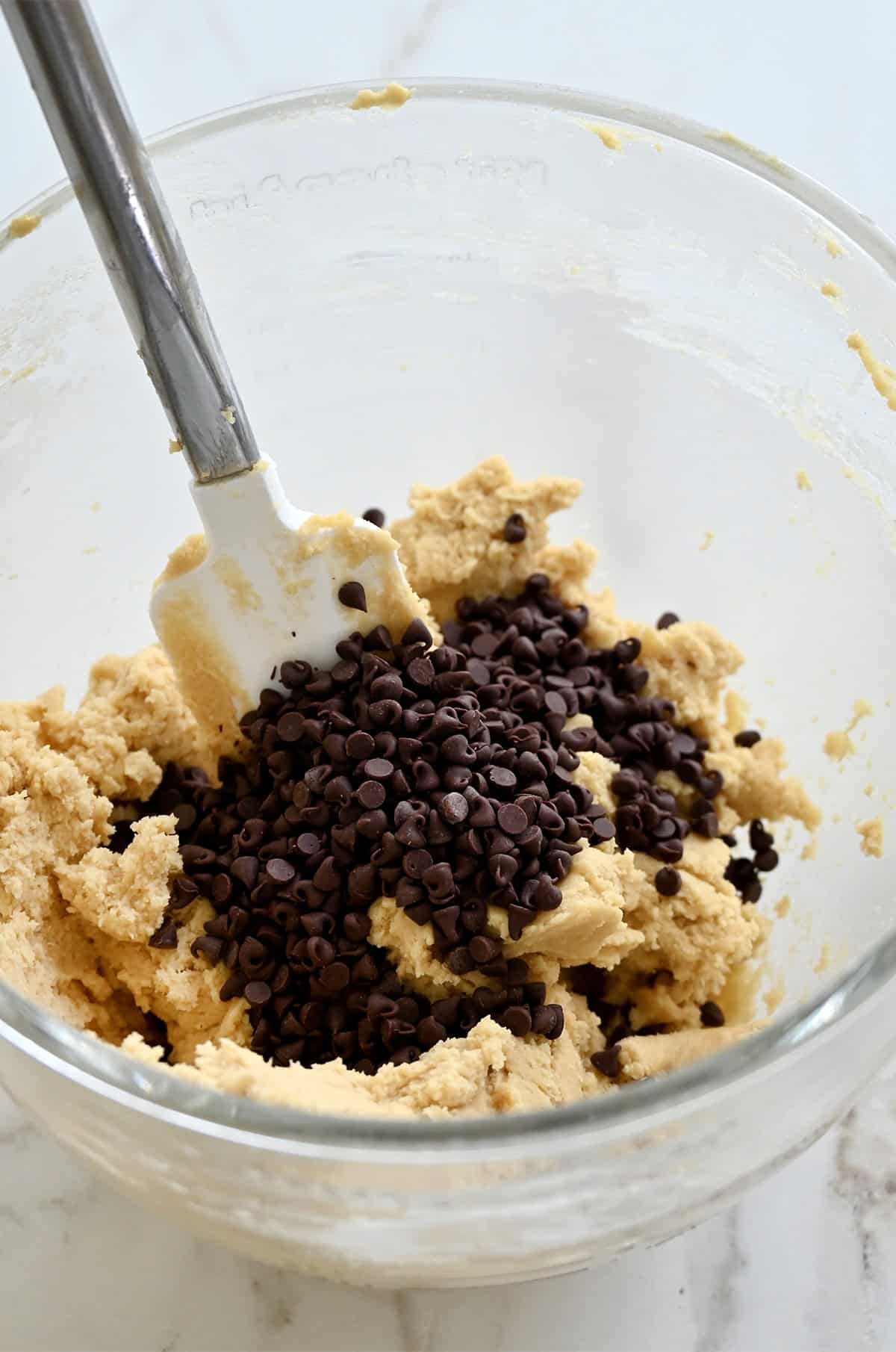 Folding in mini chocolate chips into cookie dough.