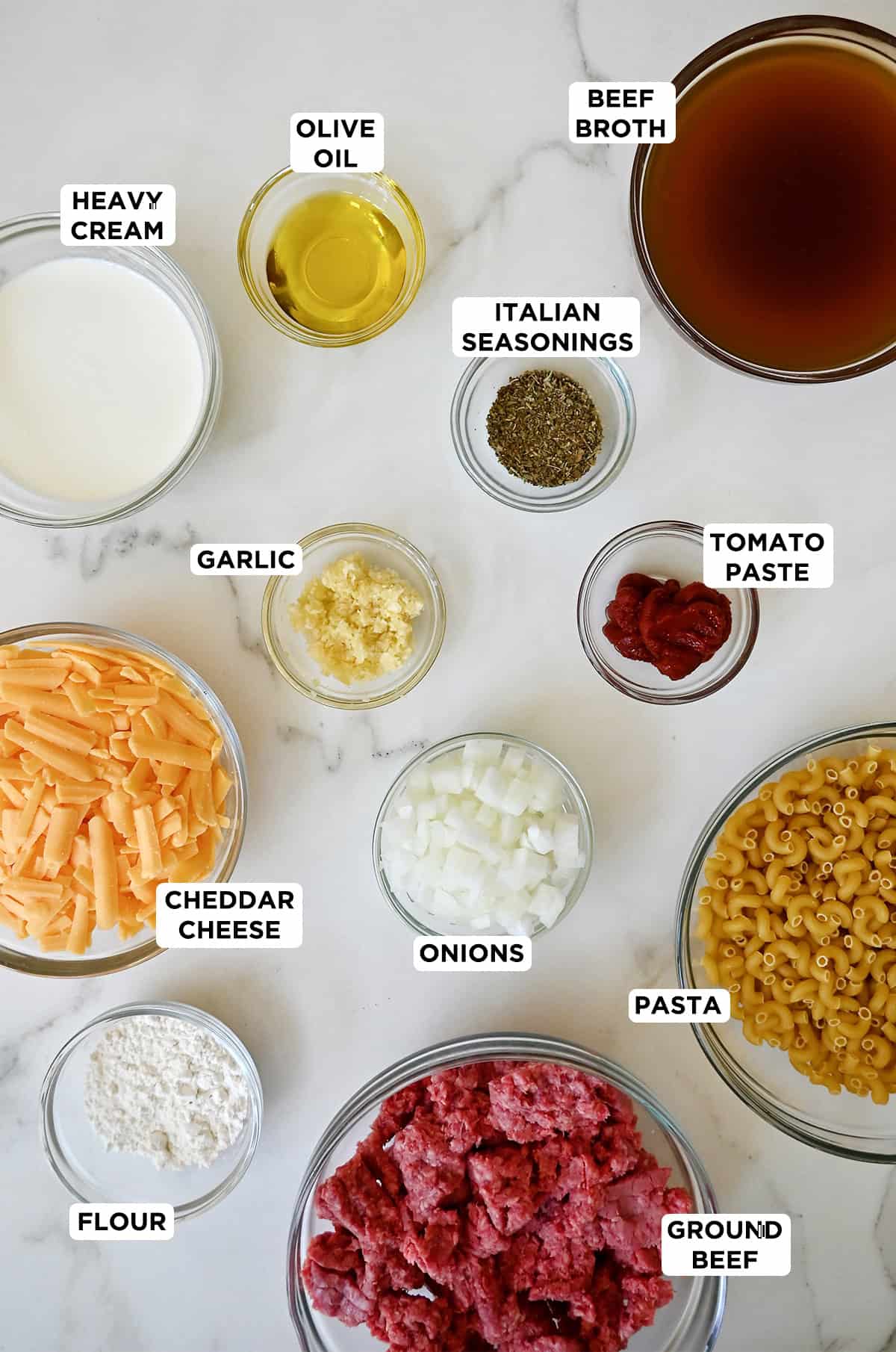 All of the ingredients needed to make DIY Hamburger Helper in various sizes of glass prep bowls.