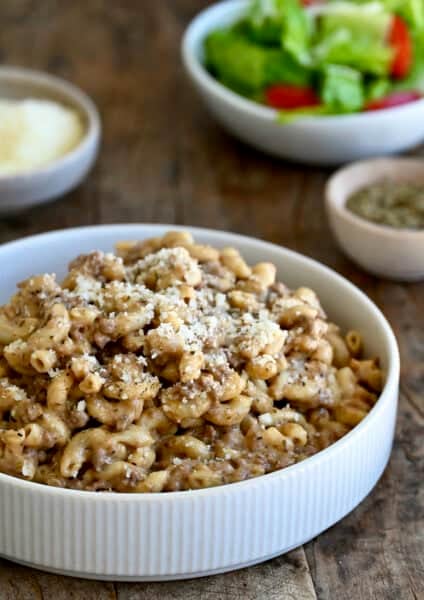 A pasta bowl containing homemade hamburger helper topped with grated Parmesan.