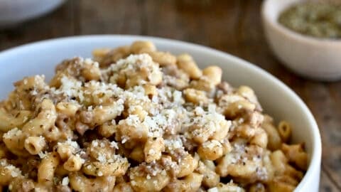 A pasta bowl containing homemade hamburger helper topped with grated Parmesan.