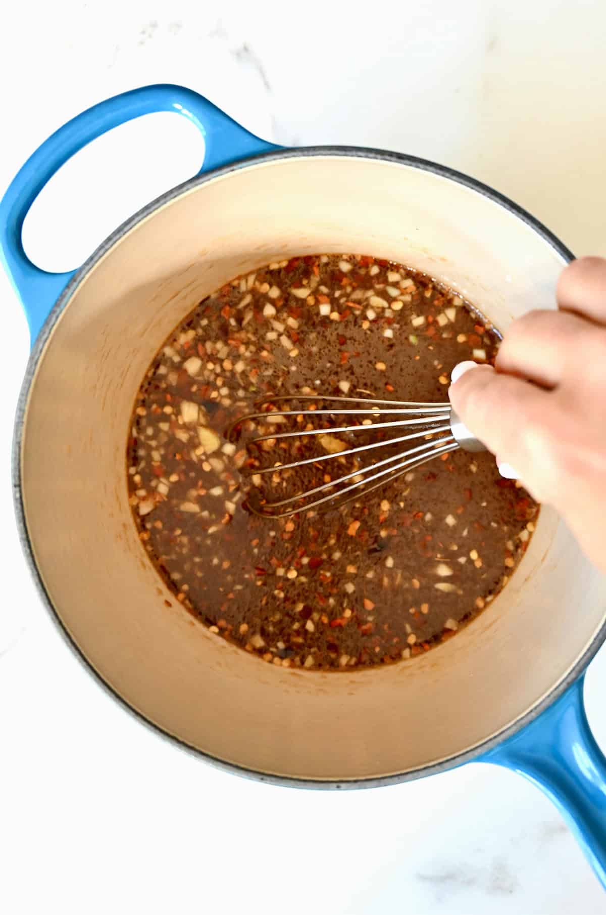 Mixing ingredients together in a small saucepan to make homemade stir-fry sauce.