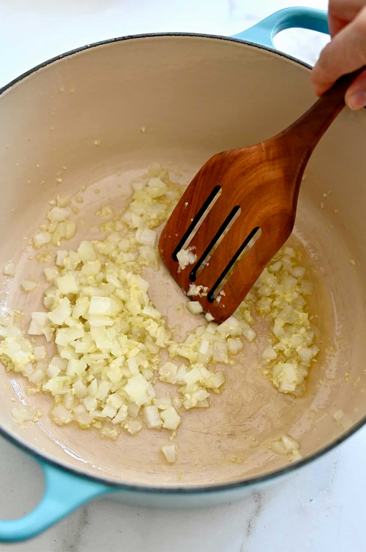 iced onions and minced garlic sautéing in olive oil in a Dutch oven.