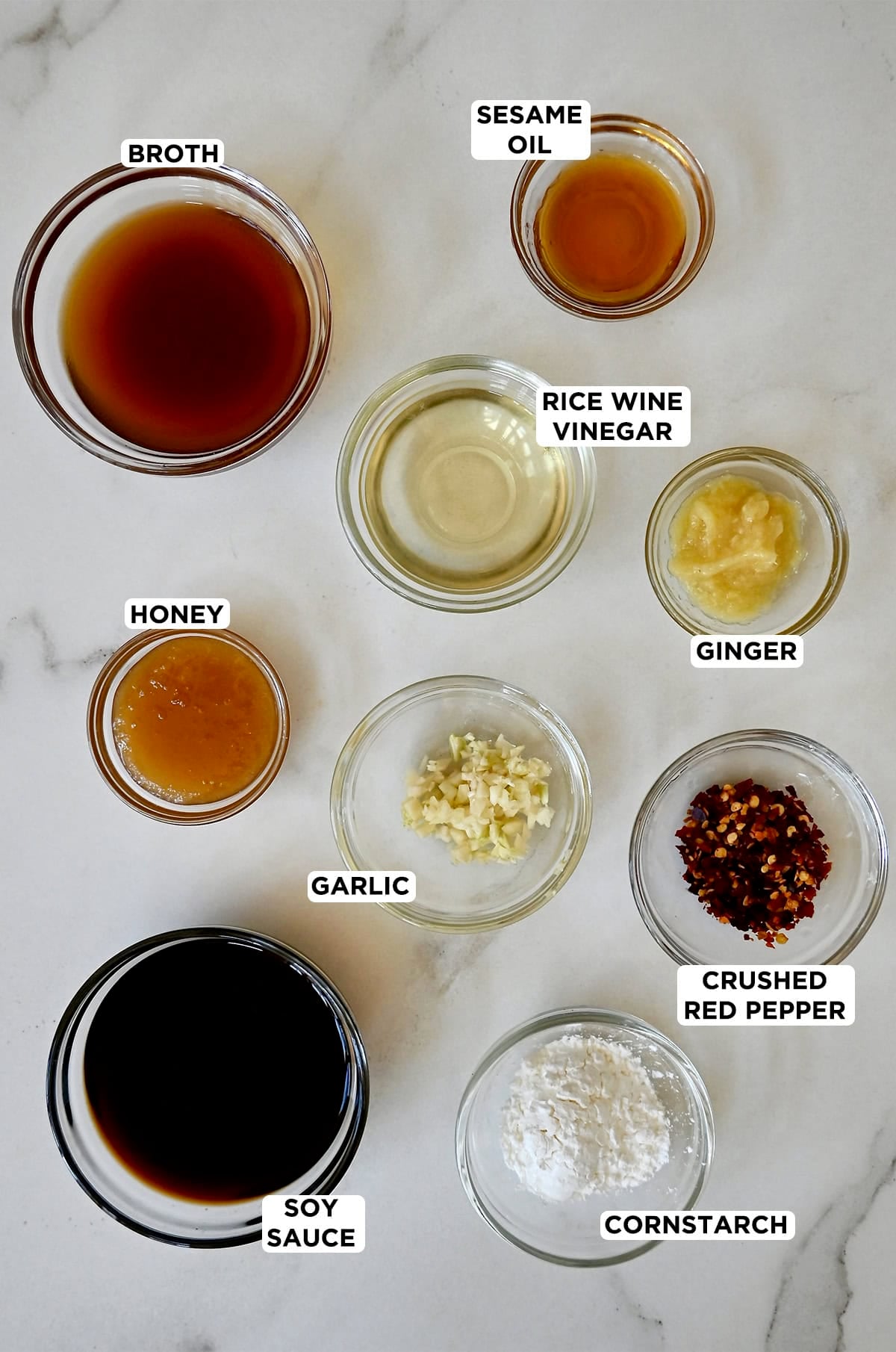 Ingredients to make stir fry sauce in various sizes of glass bowls.