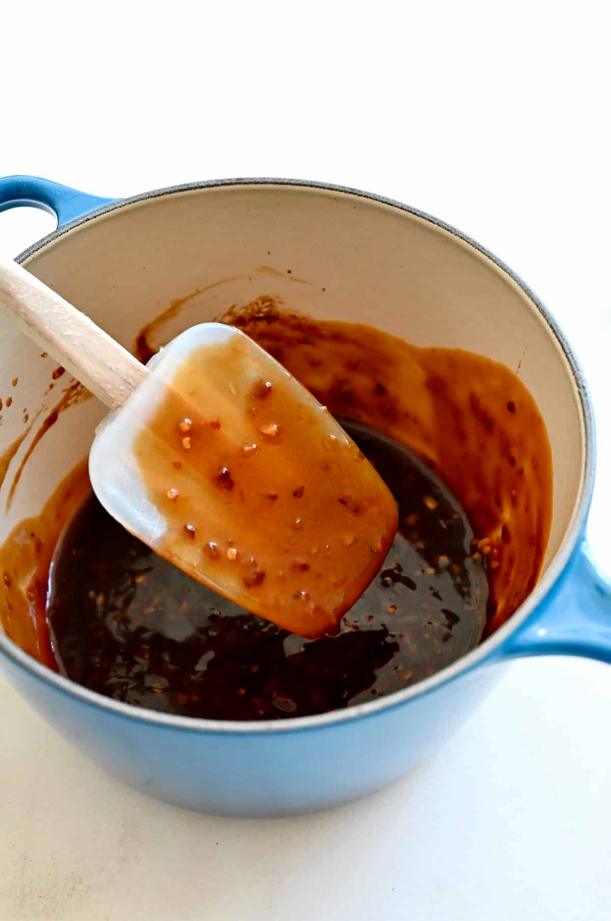 Thickened homemade stir-fry sauce coating a spatula.